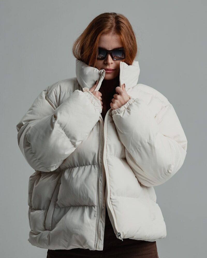 a woman wearing a white jacket and sunglasses